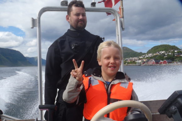 Han smiler - men han har også redningsvest på